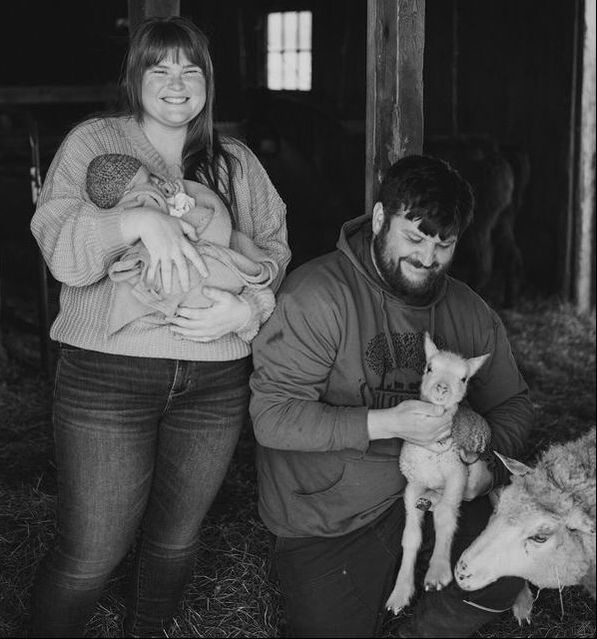 Anna and Sami in the Stargrazer barn with sheep and daughter Sawyer